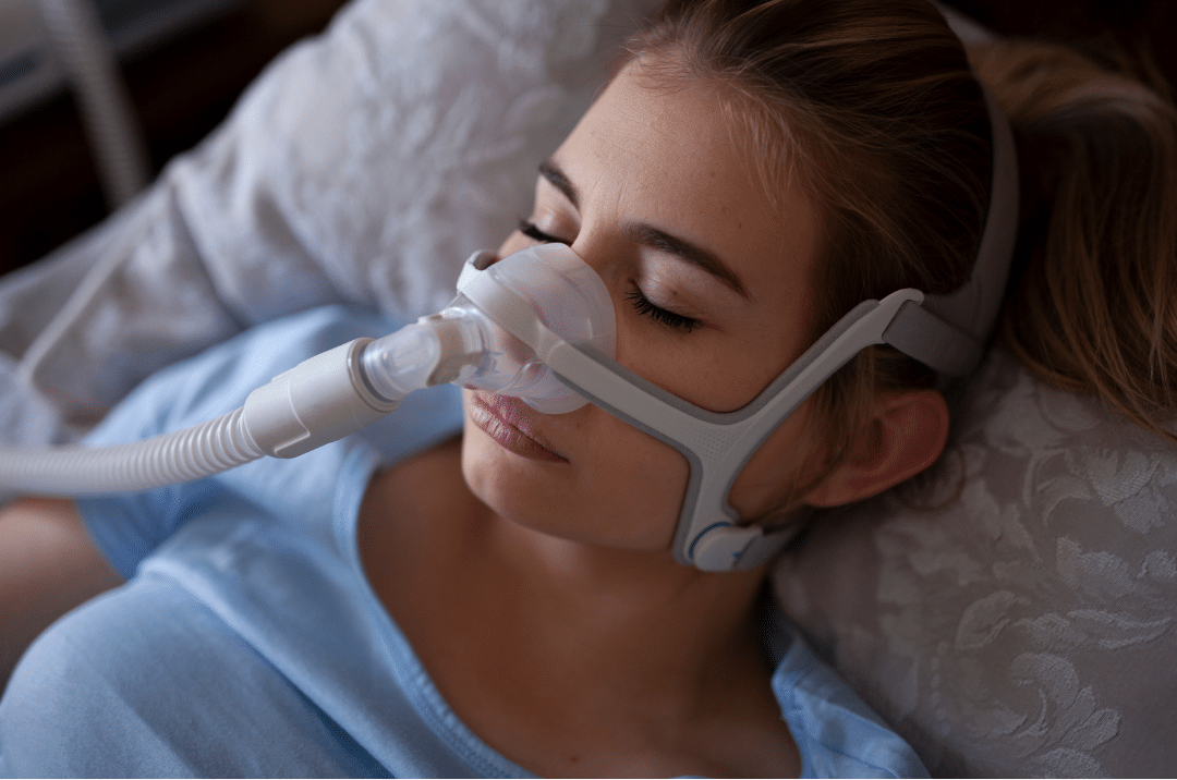 A woman sleeping comfortably while wearing a CPAP mask, which is the most common and reliable method for treating sleep apnea.